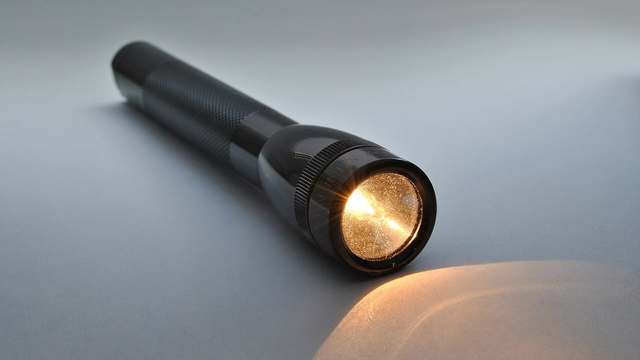 A lit handheld flashlight