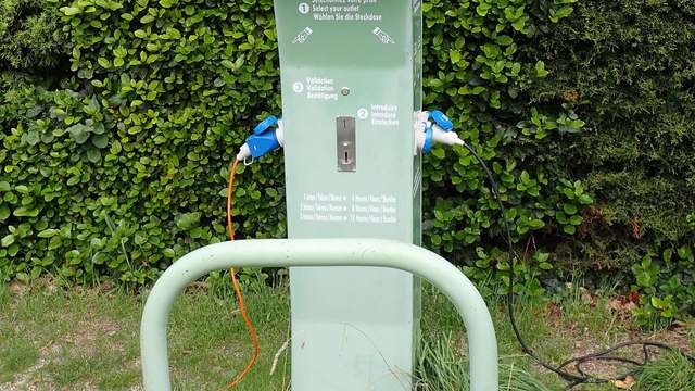 A power pedestal with blue shore-power sockets at a motorhome stopover