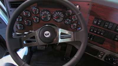 A steering wheel and dashboard in a truck cab